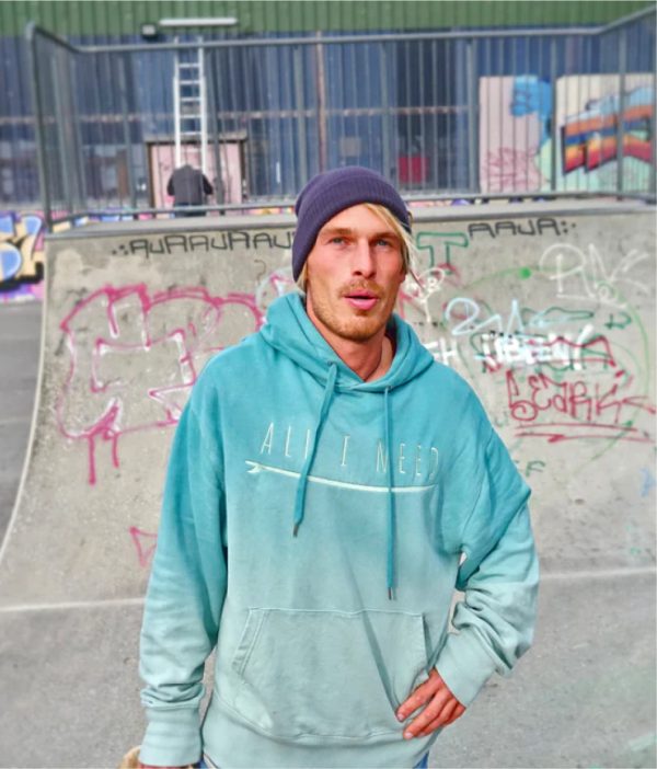 One Wave Hoodie - Ocean Petrol Aloe, Mann im Skatepark. Lässig geschnittener Hoodie mit Farbverlauf. Aus 100% Bio-Baumwolle hergestellt.