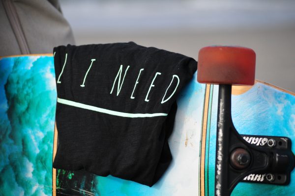 One Wave Shirt - Beach Tee Midnight Black, am Strand auf Skateboard. Lässig geschnittenes Damen T-Shirt aus 100% Bio-Baumwolle.